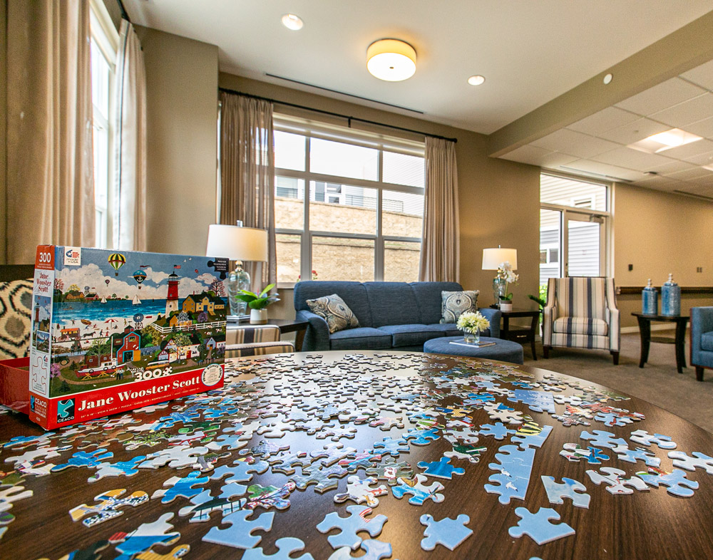 Hawkeye Care Center living area showing a close up of a round table with an incomplete puzzle on top