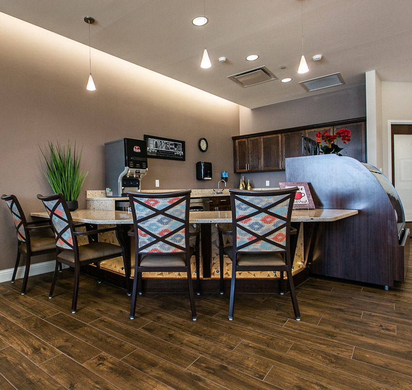 Hawkeye Care Center eating area with 4 chairs around a bar, which is in front of a kitchen area